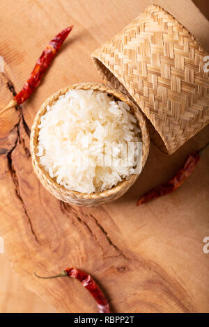 Asiatische Thai Food Glutenhaltigen oder klebrigen Reis in Bambus Rattan auf hölzernen Hintergrund mit Kopie Raum Stockfoto