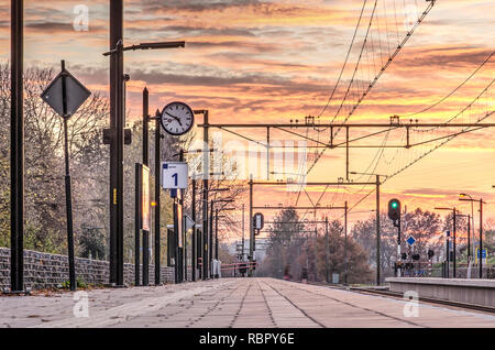 Klimmen-Ransdaal, Niederlande, 18. November 2018: Low Angle Blick entlang der Länge einer der Plattformen der Bahnhof unter einem bunten Stockfoto