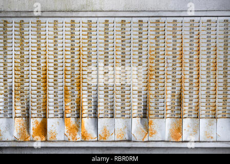Rusty Wandhalterung mit nummerierten Steckplätze für Stempelkarten in einem verlassenen Fabrikgebäude Stockfoto