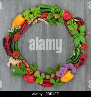 Kraut und Gewürz Kranz mit einer Auswahl von getrockneten und frischen Kräutern und Blumen auf rustikalem Holz Hintergrund. Stockfoto