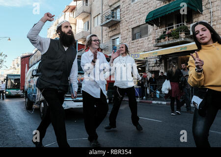 Treue Anhänger des Rabbi Nachman von Breslov brechen in Gesang und Tanz auf Agripas Street neben Mahane Yehuda Markt. Mahane Yehuda, oft re Stockfoto