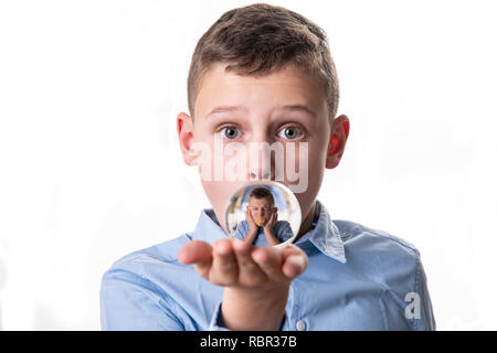 Die Wahrheit der Gefühle in die Glaskugel - Junge sieht Anblick mit einem Pflaster auf den Mund und die Hände auf die Ohren - nicht sprechen nichts hören Stockfoto