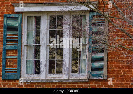 Verfallende Fensterläden Fenster auf einem die Farbe blätterte ab, die Teil einer Struktur. Stockfoto