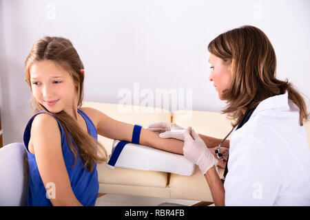 Seitenansicht der Ärztin die Blutprobe eines Angst Kind Patient in der Klinik Stockfoto