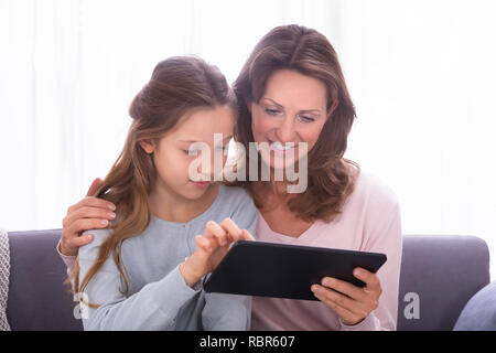 In der Nähe von Reifen Mutter mit ihrer Tochter das Surfen im Internet mit digitalen Tablet Stockfoto