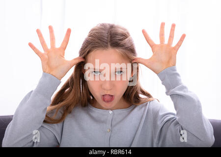 Mädchen aus Zunge, während Sie necken Gesicht Stockfoto