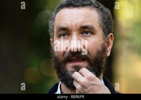 Portrait von Stattlichen 40 Jahre alter Mann mit lockigem Haar und bunt. Stockfoto