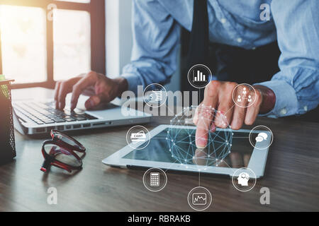 Geschäftsmann wird das Arbeiten mit digitalen Tablet und moderne Computer mit VR-Symbol Diagramm im Büro. Das digitale Marketing Medien in virtuellen Bildschirm. Stockfoto