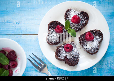 Brownie Herzförmige, mit Beeren dekoriert. Dessert Schokolade. Stockfoto