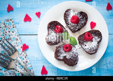 Brownie Herzförmige, mit Beeren dekoriert. Dessert Schokolade. Stockfoto