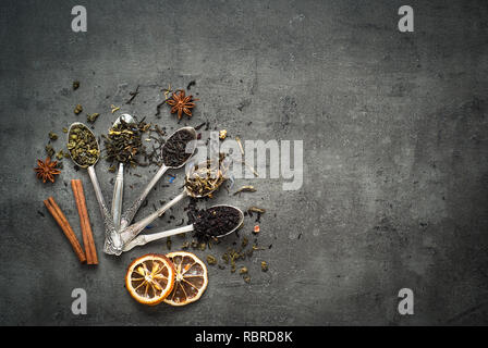 Verschiedene Arten von Tee in Löffel auf dunklem Schiefer Hintergrund. Trockene Kaffee Sortiment. Stockfoto