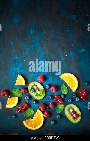 Frische Sommer Beeren und Früchte auf dunklem Hintergrund. Gesunde Ernährung Konzept. Flach. Obst Hintergrund. Stockfoto