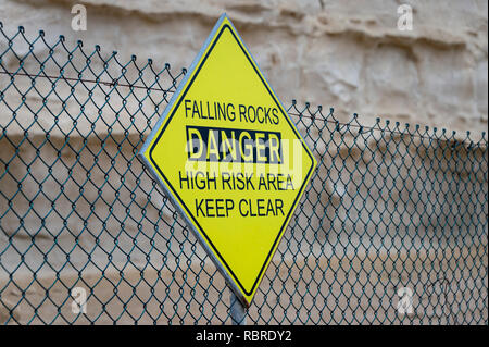 Falling Rocks, Gefahr, hohes Risiko, frei halten, Warnschild an einem Zaun. Stockfoto