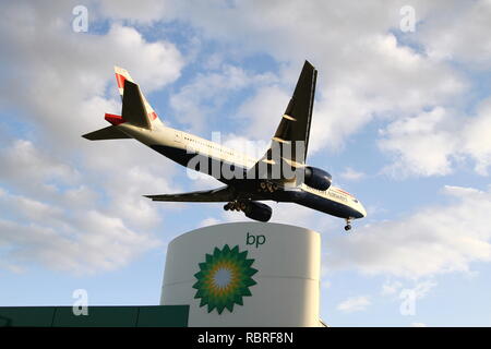 Einen British Airways Verkehrsflugzeug absteigend am Flughafen Heathrow in London über eine BP-Tankstelle zu landen. Britische Unternehmen. British Airways ist Teil der [DIAG] internationale Airline Group und British Petroleum PLC sind an der London Stock Exchange gelistet und im FTSE 100-Index. Stockfoto