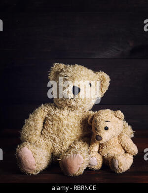 Zwei braune weiche Teddybären sitzen auf einem hölzernen Oberfläche, vintage Toning Stockfoto