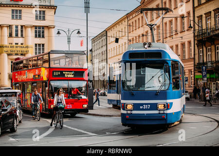 Krakau, Polen - 28. August 2018: rote Hop on-Hop off-Touristische Bus für Sightseeing in und Blau öffentliche Straßenbahn auf starowislna Straße. City Sightseeing zu Stockfoto