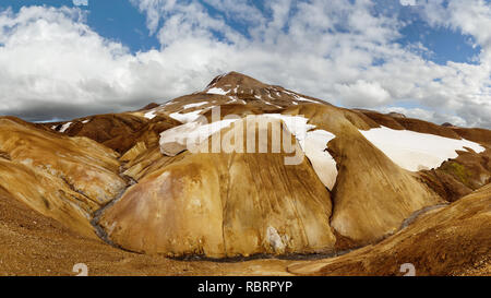 Panorama einer breiten dunklen Stein Landschaft im Hintergrund mit einem Gebirge im Abendlicht glühenden - Ort: Island, Highlands, Bergland Stockfoto