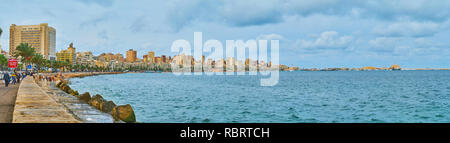 ALEXANDRIA, Ägypten - Dezember 19, 2017: Das weite Panorama der Stadt Küste mit der Zeile von Gebäuden, Üppige Palmen und Qaitbay Zitadelle auf dem Horizont, Stockfoto