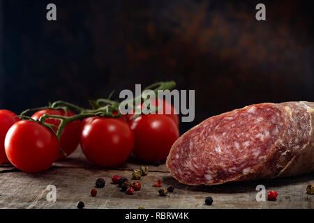 Hausgemachte italienische Salami mit Cherry Tomaten und einige Verfärbungen Pfefferkörner Stockfoto