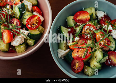 Keramik Schalen mediterraner Griechischer Salat mit Tomaten, Gurken, Schafskäse, Olivenöl extra vergine und schwarzer Pfeffer Stockfoto