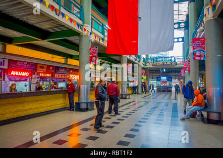 SANTIAGO, CHILE - Oktober 09, 2018: Unbekannter Menschen innerhalb der Busbahnhof an mit chilenischer Flagge hängen von der Dachterrasse wartet. Dies ist die grösste und wichtigste Busbahnhof der Stadt Stockfoto