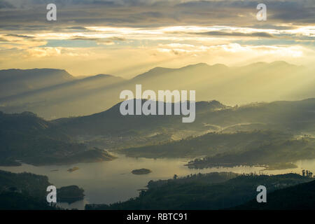 Die atemberaubende Aussicht vom frühen Morgen Adams Peak Hill, Sri Lanka über die umliegenden Hügel und Seen in der Landschaft. Stockfoto