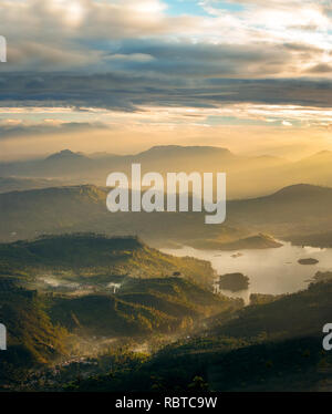 Die atemberaubende Aussicht vom frühen Morgen Adams Peak Hill, Sri Lanka über die umliegenden Hügel und Seen in der Landschaft. Stockfoto