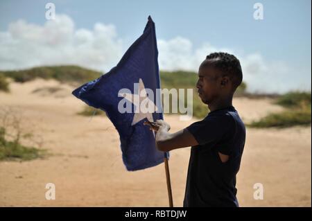 Ein junger Mann trägt die somalische Fahne während der Führung einer Gruppe von Soldaten, die während einer Demonstration durch einen lokalen Milizen, gebildet, um die Sicherheit in der Nähe von Marka, Somalia, am 30. April. AU UN (14081070785). Stockfoto