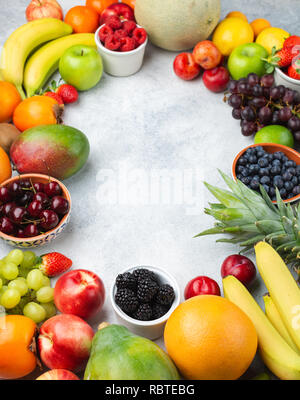 Gesunde Frucht Hintergrund Rahmen, Pflaumen Erdbeeren Himbeeren Orangen, Äpfel, Kiwis, Weintrauben, Heidelbeeren mango Kaki am weißen Tisch Stockfoto