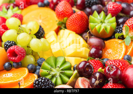 Gesunde Frucht Hintergrund mit Erdbeeren Himbeeren orangen Pflaumen Äpfel gefüllt, Kiwis, Weintrauben, Heidelbeeren mango Kaki Ananas Stockfoto