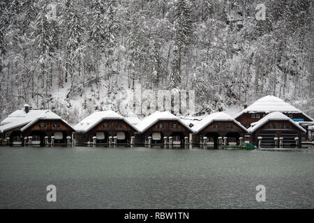 12 Januar 2019, Bayern, Schönau am Königssee: ein Boot übergibt schneebedeckten Bootshäusern. Die starken Schneefälle der vergangenen Tage weiterhin den Einsatzkräften in Atem im südlichen Bayern und Neuschnee zu halten ist schon näher. Nach Angaben der Behörden mehr als 1000 Helfer sind in den südlichen Bezirken von Oberbayern eingesetzt. Foto: Lino Mirgeler/dpa Stockfoto