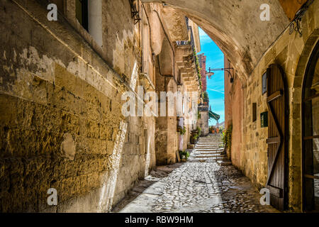 Eine überdachte Gasse führt zu einem Cafe und Piazza in der antiken Stadt Matera, Italien Stockfoto