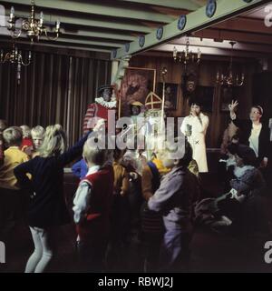 Aankomst Sinterklaas in Volendam Sint en Piet met Mies Bouwman in zaal, Bestanddeelnr 254-8745. Stockfoto