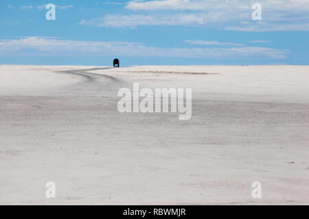 Ein Allradantrieb (4WD) Tour über die Salzwüste von Uyuni, eine Straße zu den Horizont folgt. Stockfoto