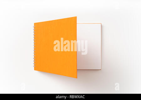 Designkonzept - Ansicht von oben orange gebunden Spirale Notebook mit offener Abdeckung an Hintergrund für Mockup isoliert. Nicht für 3D-Rendering Stockfoto
