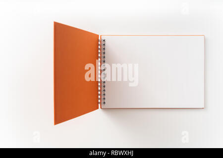 Designkonzept - Ansicht von oben orange gebunden Spirale Notebook mit offener Abdeckung an Hintergrund für Mockup isoliert. Nicht für 3D-Rendering Stockfoto