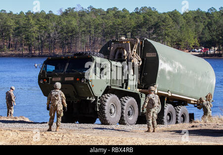 Soldaten aus der 502Nd Multi-Role Bridging Company, 19 Techniker Bataillon, senkte ein Segment des Ribbon bridge in das Wasser am MacArthur See, Fort Bragg, N.C. Jan. 9, 2019. Ribbon Brücken miteinander verbunden sind eine ganze Brücke über das Gewässer zu bilden. (U.S. Armee Foto von Sgt. Gin-Sophie De Bellotte) Stockfoto