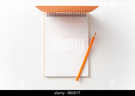 Designkonzept - Ansicht von oben orange gebunden Spirale Notebook mit offener Abdeckung an Hintergrund für Mockup isoliert. Nicht für 3D-Rendering