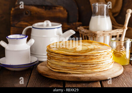 Hausgemachte dünne Pfannkuchen mit Honig, Pfannkuchen auf Holz rustikale Hintergrund Stockfoto