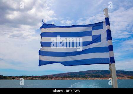 Griechische Flagge weht im Wind auf der Rückseite einer Fähre nach Kefalonia. Stockfoto