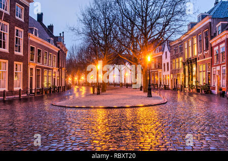 Leiden, Niederlande, 7. Januar 2019: Das Licht des od-altmodische Straßenlaternen spiegelt sich auf dem Kopfsteinpflaster der ehemaligen canal Hooglandse Ke Stockfoto