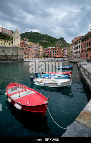 Dramatische Wolkenhimmel über Vernazza Hafen, mit einige Boote im Vordergrund. Cinque Terre, Italien. Stockfoto