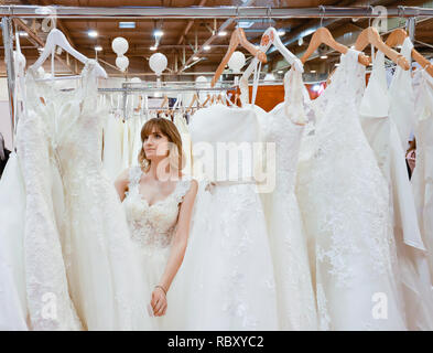 Frau in einem Hochzeitskleid Verschraubung an der Hochzeitsmesse. Präsentiert Szene mit einem Modell aus der Messestand. Essen, Nordrhein-Westfalen, Deutschland, Eur Stockfoto