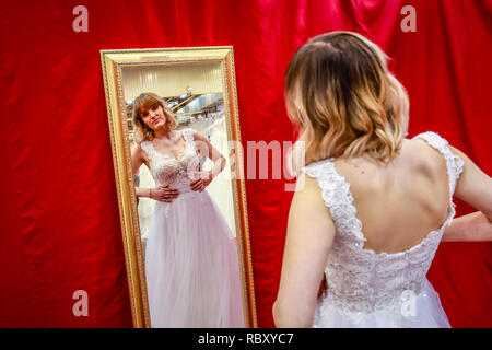 Frau in einem Hochzeitskleid Verschraubung an der Hochzeitsmesse. Präsentiert Szene mit einem Modell aus der Messestand. Essen, Nordrhein-Westfalen, Deutschland, Eur Stockfoto