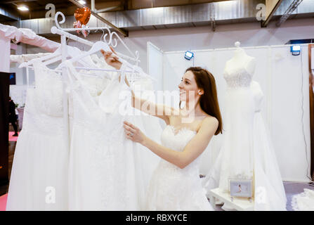 Frau in einem Hochzeitskleid Verschraubung an der Hochzeitsmesse. Präsentiert Szene mit einem Modell aus der Messestand. Essen, Nordrhein-Westfalen, Deutschland, Eur Stockfoto