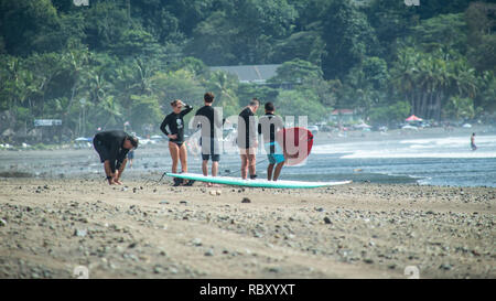 Eine Gruppe von Menschen die Vorbereitung für eine surfsession am schönen Jaco Beach, Costa Rica Stockfoto