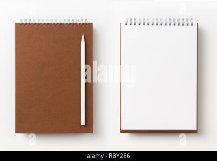 Designkonzept - Ansicht von Oben braun Spirale notebook, weiße Seite und Bleistift isoliert auf Hintergrund für mockup Stockfoto