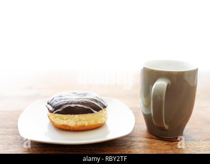 Jelly Donut und Kaffee Tasse auf hölzernen Tisch Stockfoto