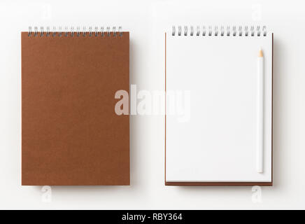 Designkonzept - Ansicht von Oben braun Spirale notebook, weiße Seite und Bleistift isoliert auf Hintergrund für mockup Stockfoto