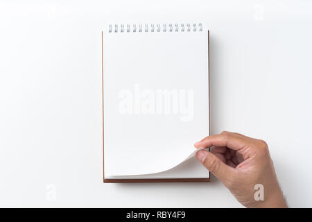 Designkonzept - Perspektivische Ansicht braun hardcover Spirale notebook, Hand des Menschen flip curl Seite auf Hintergrund für Mockup isoliert Stockfoto